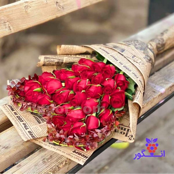 دسته گل رز قرمز همراه با برگ های زینتی