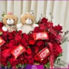 2 عدد عروسک زیبا و شکلات های خوشمزه به همراه گلهای رز و داوودی و گل عروس در باکس گل لاکچری و خاص پسند