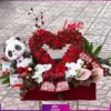 باکس گل به همراه ارکیده سفید و آنتوریوم صورتی و استند قلب شکل با گل رز مینیاتوری به همراه شکلات و عروسک پاندا
