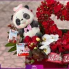 عروسک خرس زیبا با شکلات و ارکیده سفید و رزهای مینیاتوری قرمز در باکس گل عاشقانه